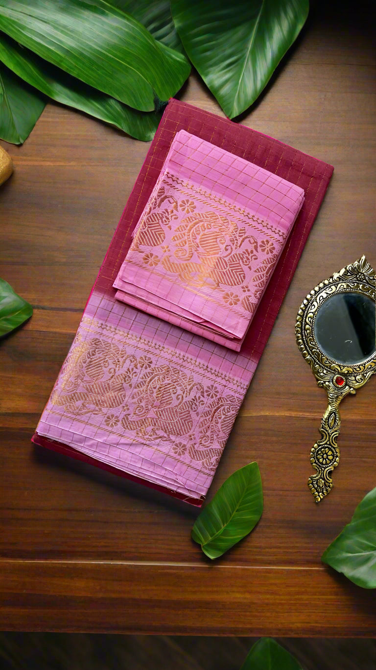 Pink fabric with gold patterns on a textured surface with decorative elements.