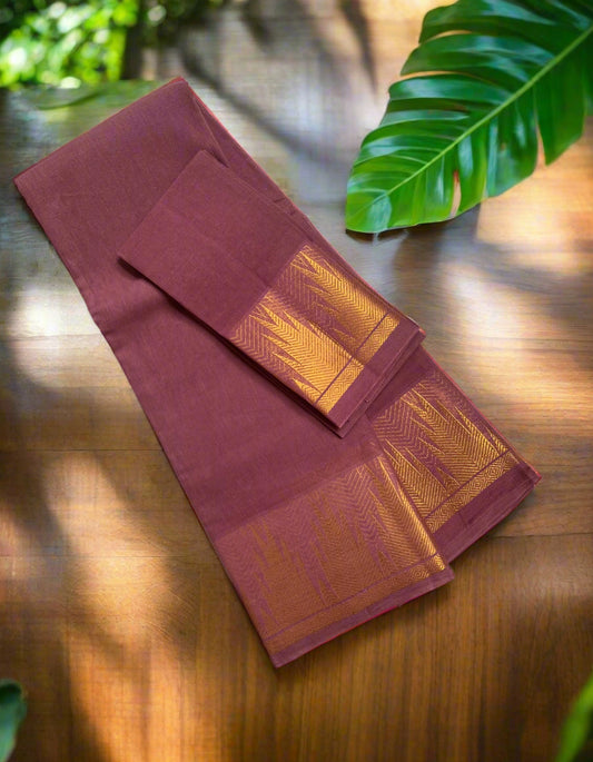 Maroon and orange saree with a white border on a wooden surface.