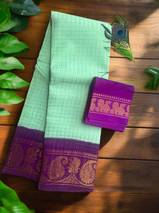 Light green saree with purple border and matching pallu on a textured surface