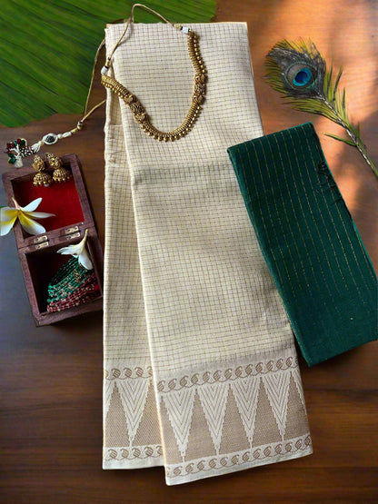 Beige saree with white border on a textured surface with jewelry and peacock feather.