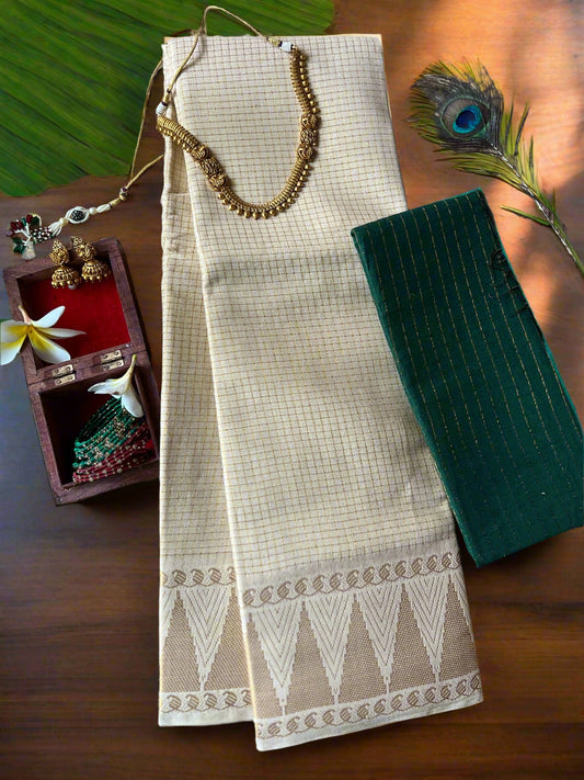 Beige saree with white border on a textured surface with jewelry and peacock feather.