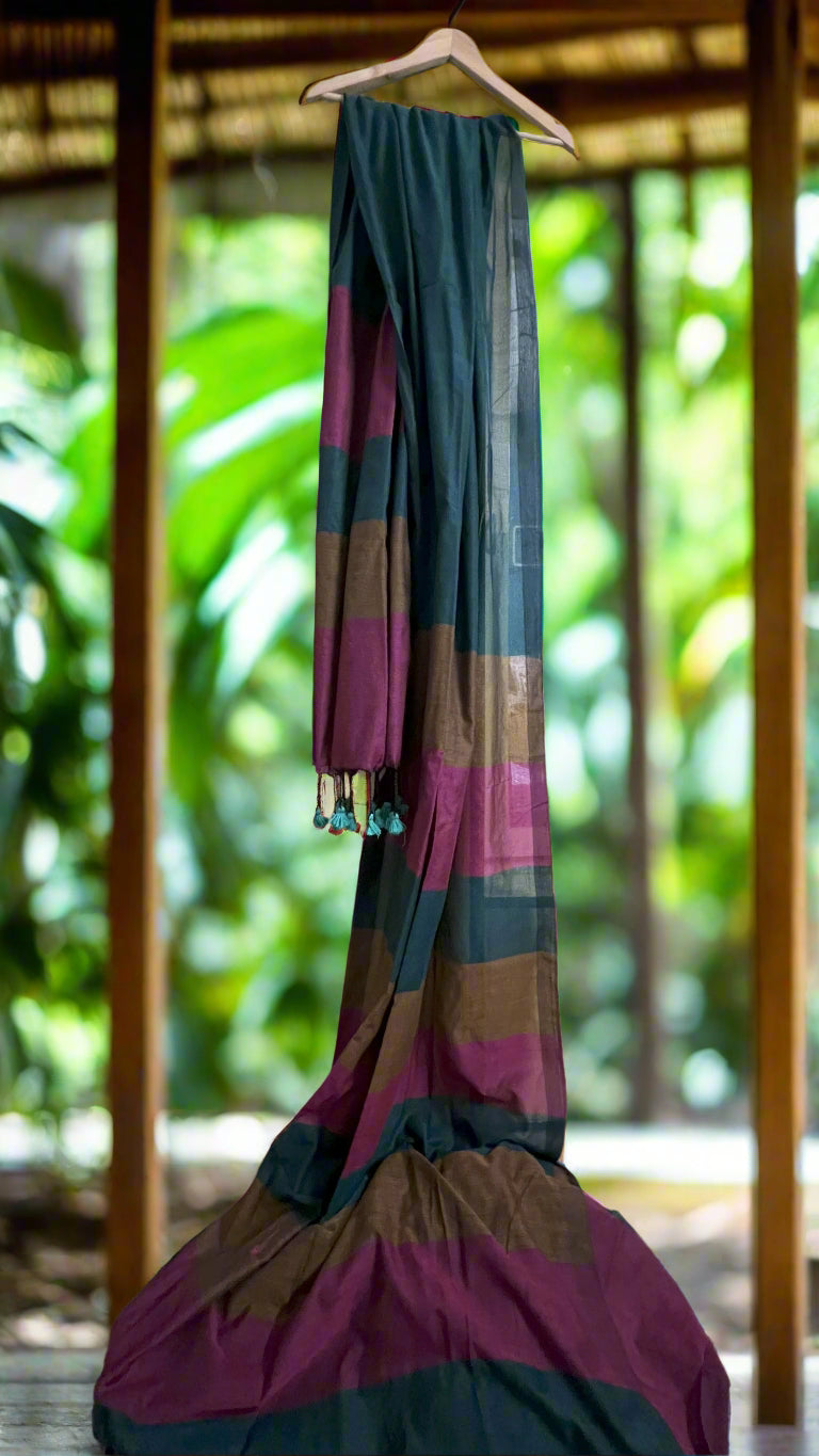 Colorful striped fabric hanging on a hanger against a mirror reflection.