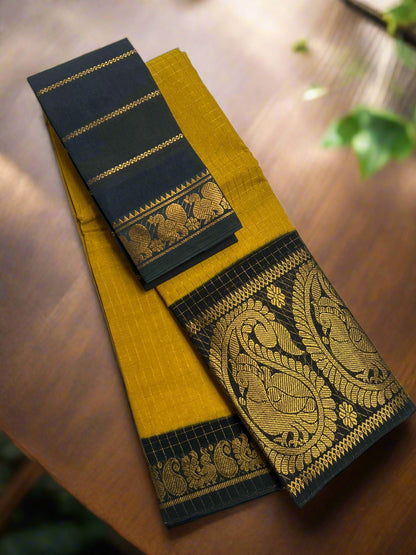 Yellow saree with black border featuring gold embroidery on a white surface.