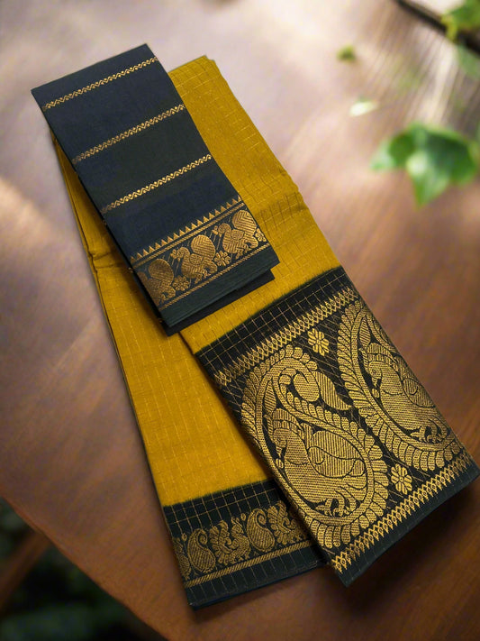 Yellow saree with black border featuring gold embroidery on a white surface.