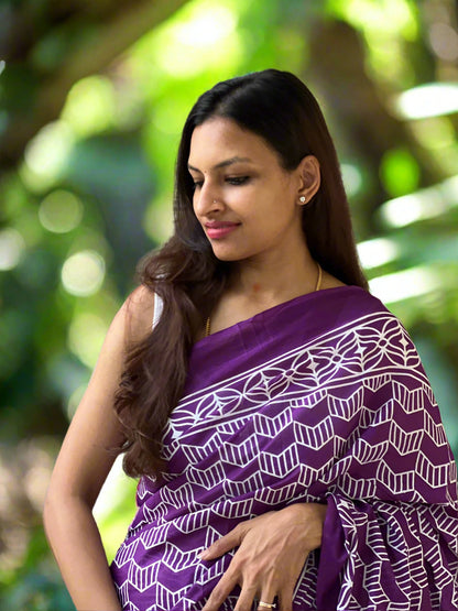 Woman wearing a purple patterned shawl against a stone wall