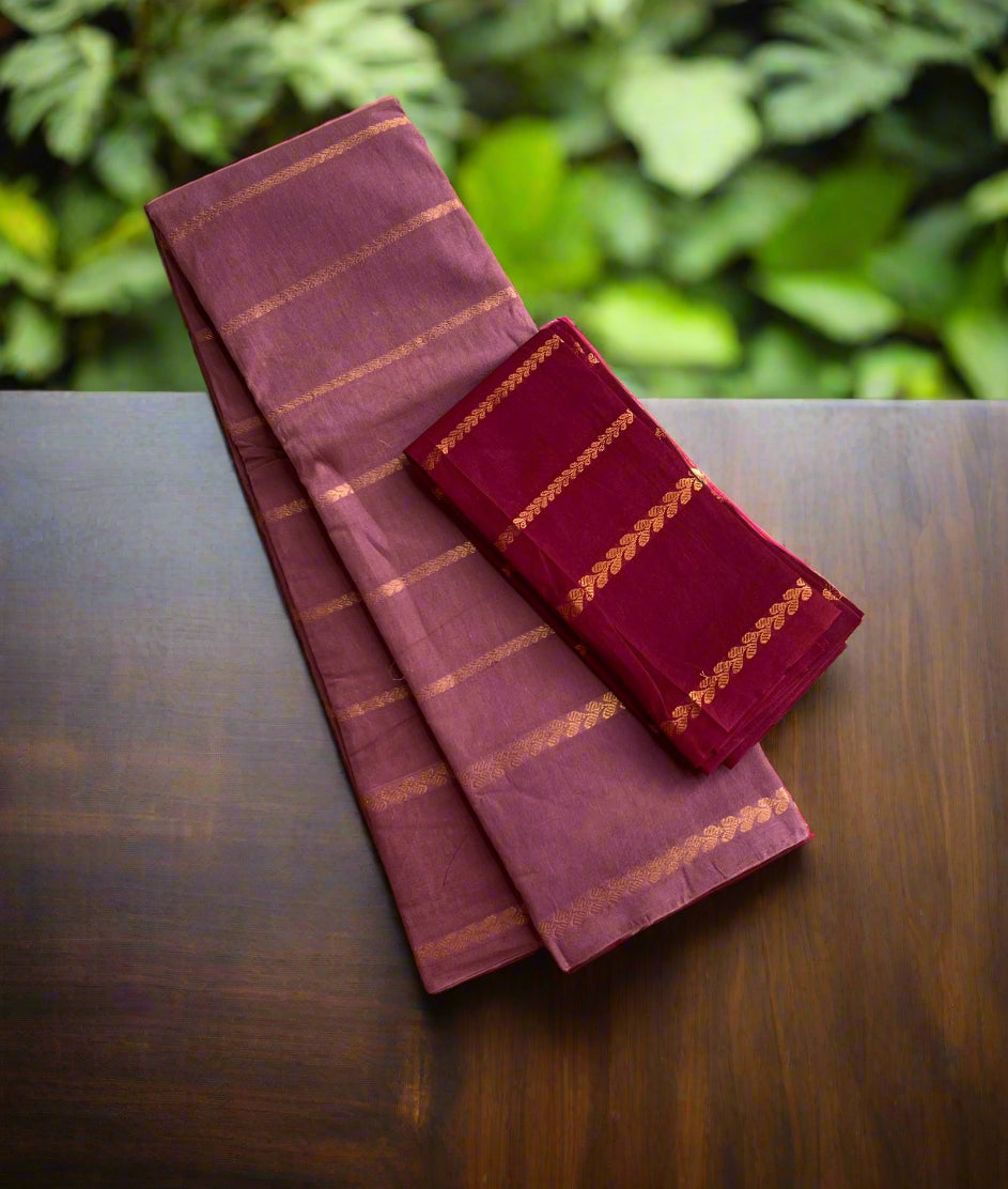 Two maroon sarees with gold stripes on a woven mat
